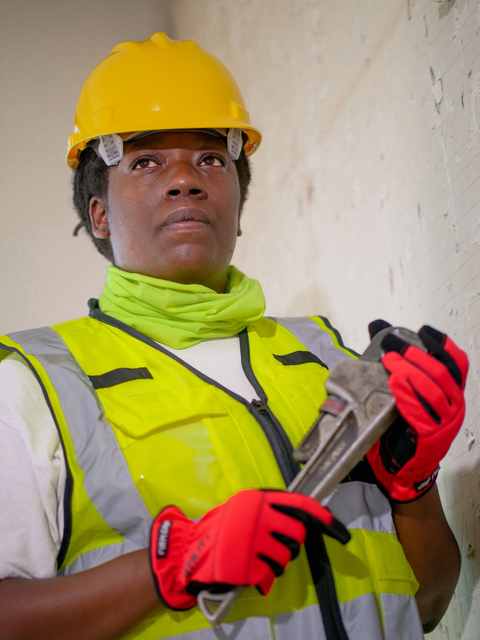 A home service technician in protective work gear holding a wrench