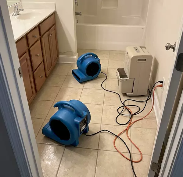 Air-moving and dehumidifying equipment set up in a residential bathroom